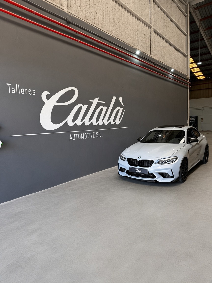 BMW M2 blanco frente al logotipo de Talleres Català en el taller de Picassent